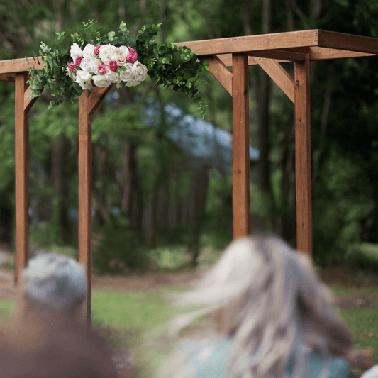 Wooden arch with floral decorations in a forest setting