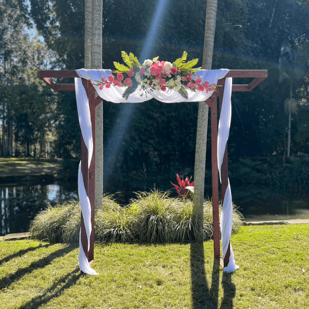 Decorative arch with flowers and ribbons in a park setting