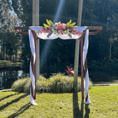 Decorative arch with flowers and ribbons in a park setting
